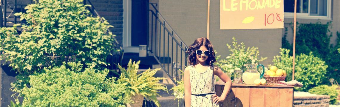 Girl selling lemonade at home stand