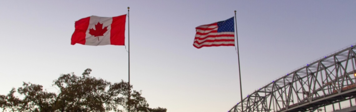 Canadian and American flags at U.S.-Canada border.