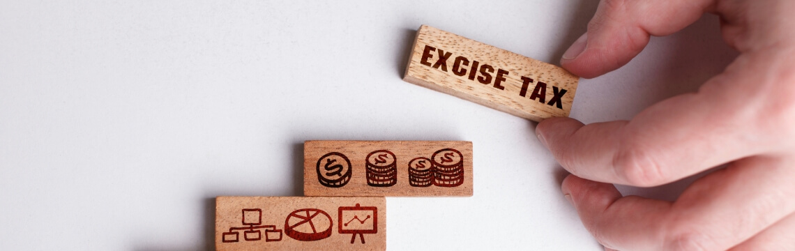 Hand moving wooden blogs depicting excise tax. 