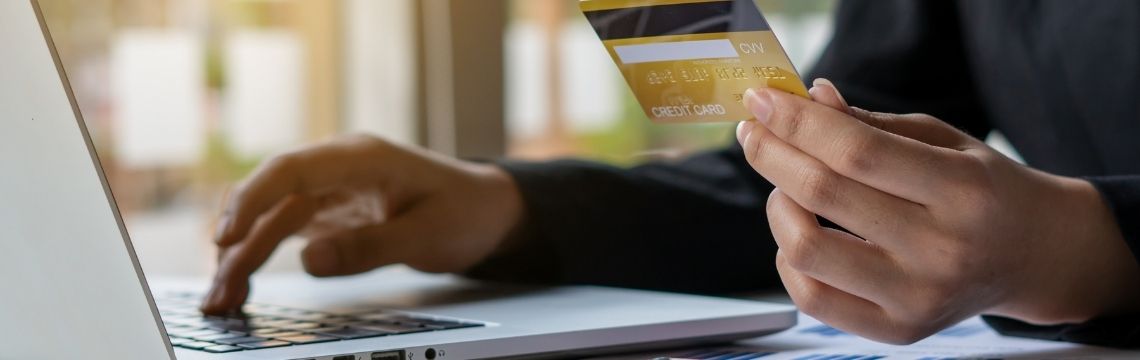 business hands holding credit card and using laptop computer for online shopping