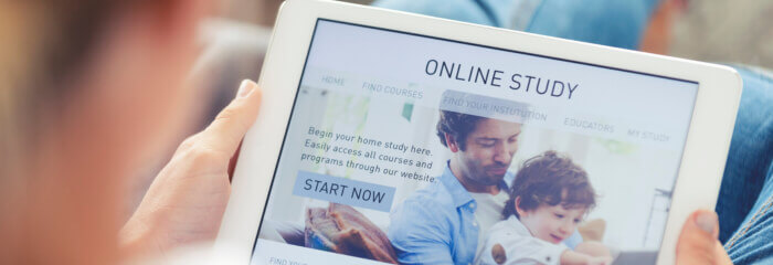 Person sitting down holding tablet with Online Study on the screen