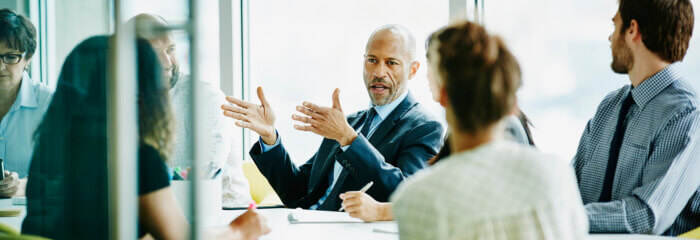 A businessman gesturing at a boardroom table