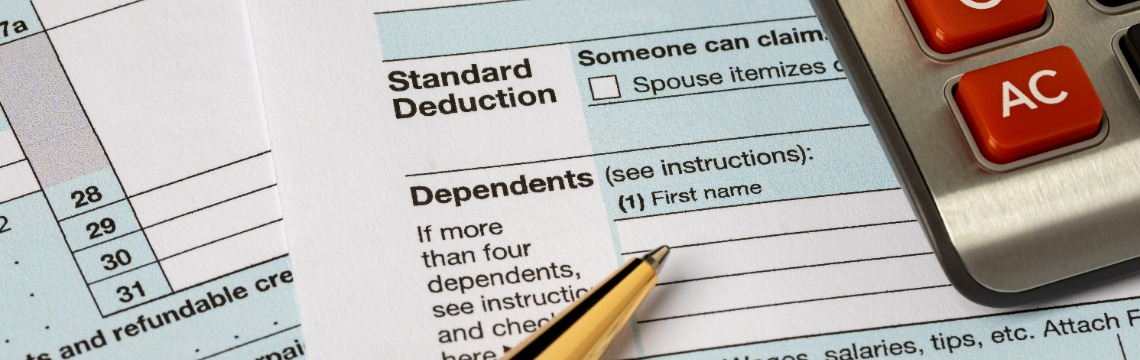 IRS form featuring the standard deduction, with a pen and a calculator. 