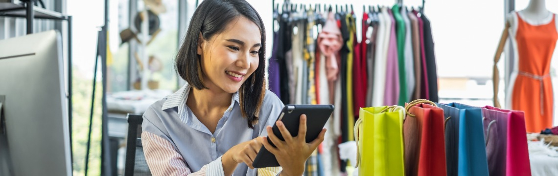 Person working on a computer and holding virtual renditions of invoices in one hand. 