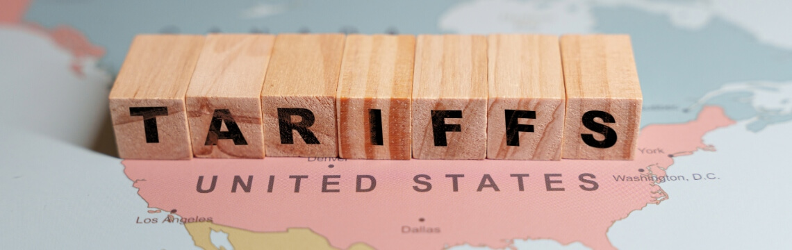 Woman reviewing financial data on a monitor while using a calculator at her desk