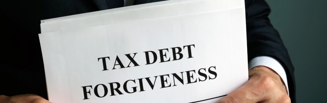 Businessperson holding paper reading “tax debt forgiveness”